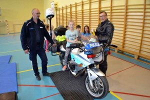 Uczennica szkoły wciela się w rolę policjanta siedząc na policyjnym motocyklu