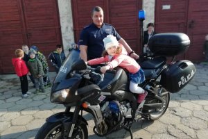 Policjant pokazuje dziewczynce jak uruchomić motocykl