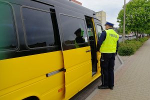 Policjanci kontrolują dokumenty kierowcy autobusu