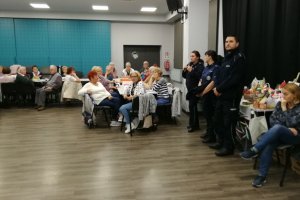Seniorzy słuchają prelekcji policjantki