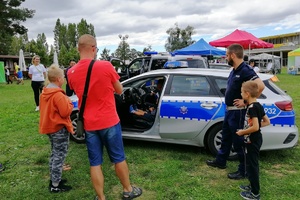 Uczestnicy festynu oglądają policyjny radiowóz