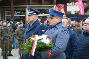 Przedstawiciele kadry świeckiej Policji oczekują z wiązanką pod pomnikiem