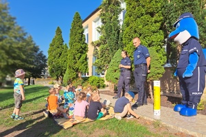 Policjanci rozmawiają z najmłodszymi przedszkolakami, które siedzą na kocach
