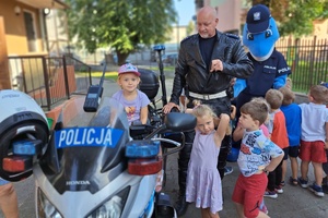 Policjant prezentuje motocykl służbowy dzieciom