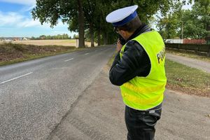 Policjant ruchu drogowego mierzy prędkość pojazdu