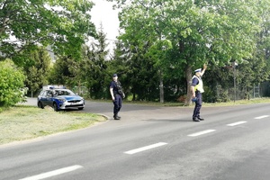 Policjant unosi rękę do góry wskazując kierowcy aby zatrzymał pojazd