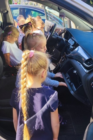 Najmłodsi zwiedzają radiowóz na dziedzińcu szkoły