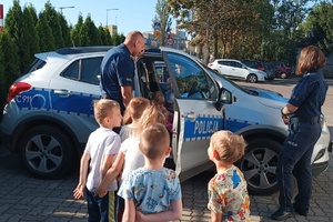 Policjanci prezentują swój radiowóz dzieciom