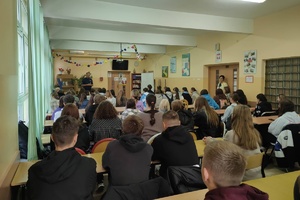 Mundurowy rozmawia z dużą grupą uczniów