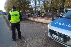 Policjant kontroluje ruch pojazdów w rejonie cmentarza