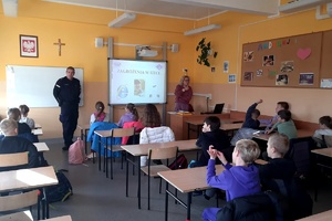 Policjant prowadzi w klasie pogadankę z uczniami