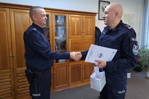 Komendant mł. insp. Marek Mitura gratuluje policjantowi jubileuszu