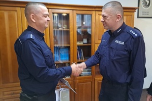 Komendant komisariatu asp. szt. Paweł Nowicki gratuluje policjantowi jubileuszu