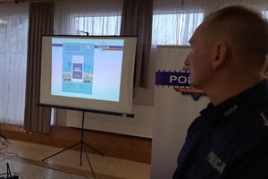 Profil policjanta, w tle pokaz dotyczący aplikacji policyjnej