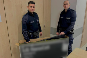 dwaj umundurowani policjanci trzymają odzyskany telewizor