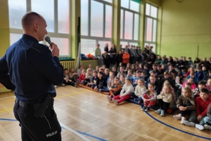 Policjant prowadzi pogadankę z uczniami szkoły