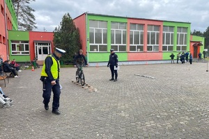 Policjant kontroluje przejazd rowerzysty po torze